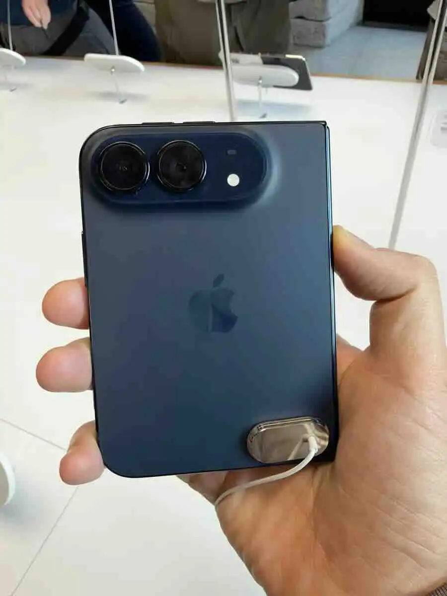 Rear of the closed blue iPhone Duo held in one hand, showing its two cameras