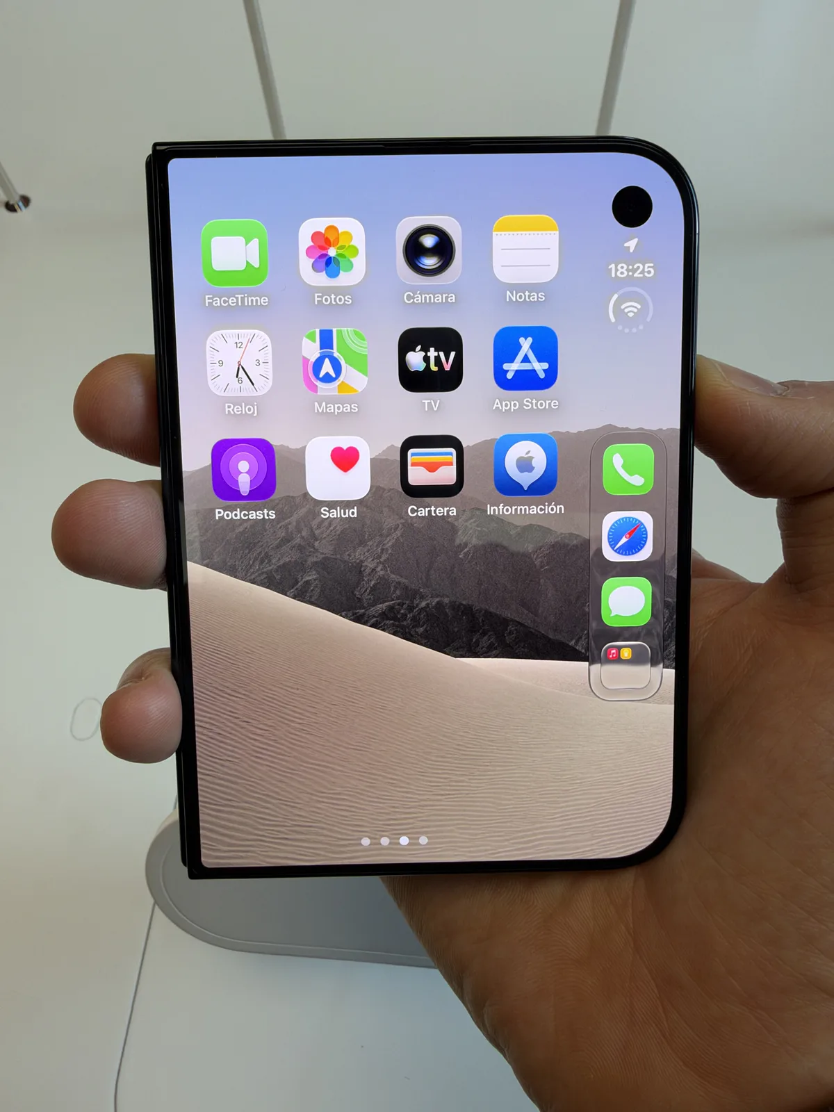 iPhone Duo outer display held upright in an Apple Store, showing app icons