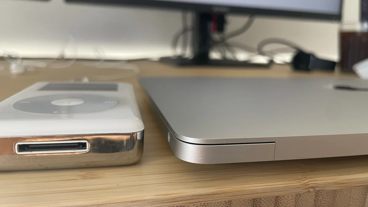 Close-up of an M1 MacBook Air beside a classic iPod with a 30-pin connector