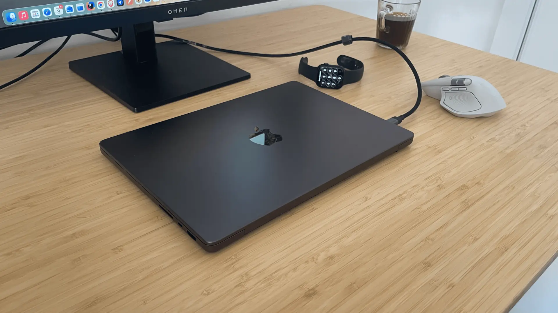 MacBook Pro M4 Pro connected to an external monitor with Apple Watch and mouse on the desk